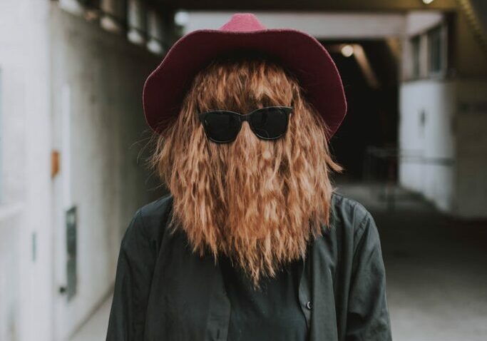 person s face covered with hair wearing sunglasses